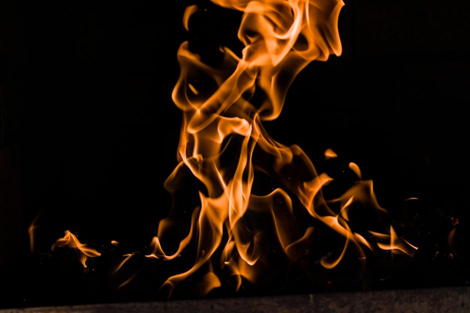 A captivating close-up of vibrant orange flames dancing against a black background, showcasing the beauty and energy of fire.