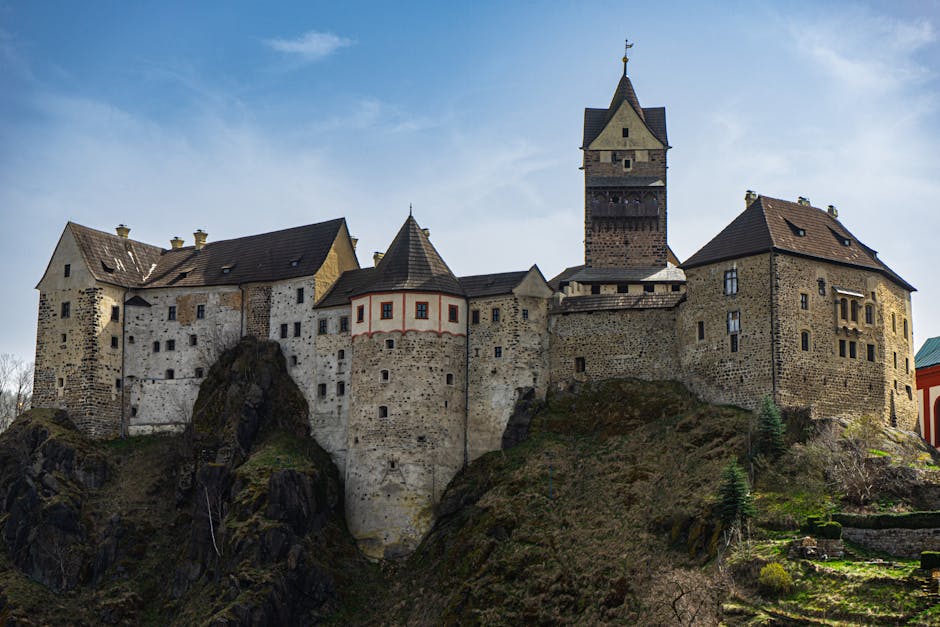 Stunning view of a historic Gothic castle perched on a rocky cliff under a clear sky.