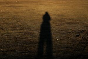 Dark silhouette shadow cast on a golden field creates a mysterious and intriguing scene.