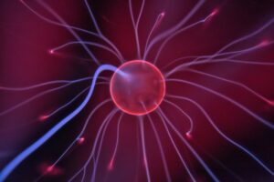 Close-up of a glowing plasma ball with colorful electric currents reaching outwards.