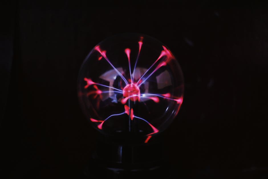 Crystal glass plasma ball with glowing electric lights inside placed in dark room